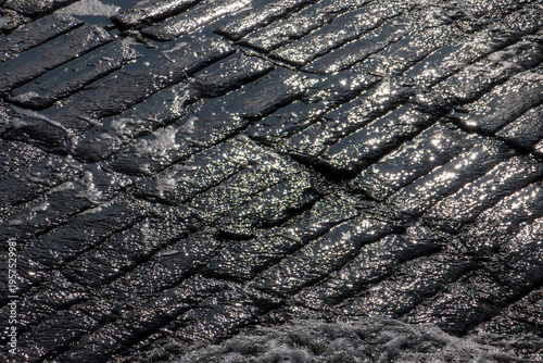 pavés humide reflétant la lumière