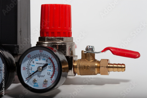 Air compressor pressure switch control assembly with dual gauges, adjustment knob, and safety valves, professional pneumatic regulation unit isolated on white.