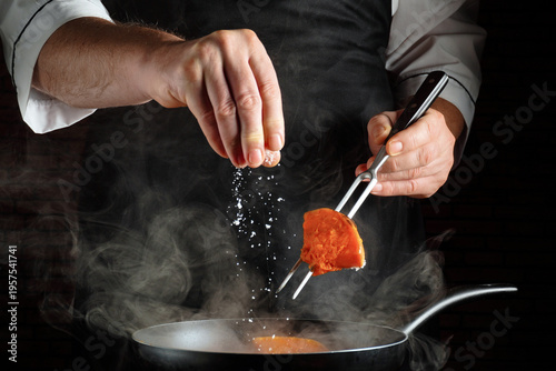 Valokuva A chef is focused on cooking in a kitchen