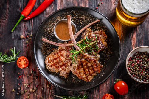 Top view grilled lamb chops with rosemary and beer on rustic table
