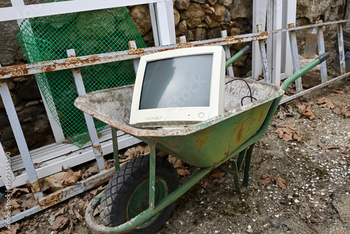 old computer abandoned outdoors in wheelbarrow