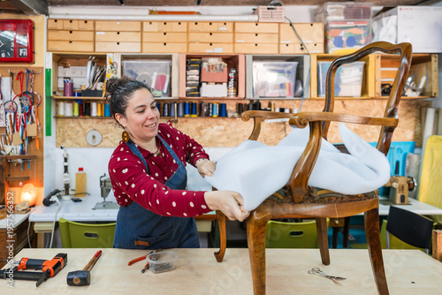 Obraz na plátně Woman artisan working in workshop, professionally restoring vintage furniture