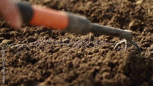 Farmer using a hand hoe  loosening fertile soil for planting