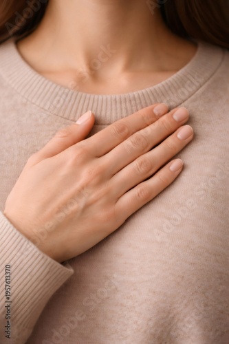 Person placing a hand over their heart, showing a gesture of honesty, gratitude, loyalty, or self love, representing feelings of warmth, care, and consciousness