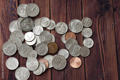 Top view of scattered coins on a rustic wooden table, symbolizing savings, finance, economy, and money management. Minimalist composition with natural texture, ideal for business, budgeting, investmen