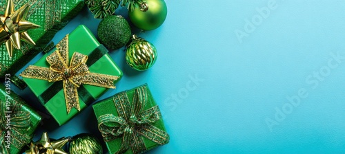 Green gift boxes and ornaments on a turquoise background with copy space