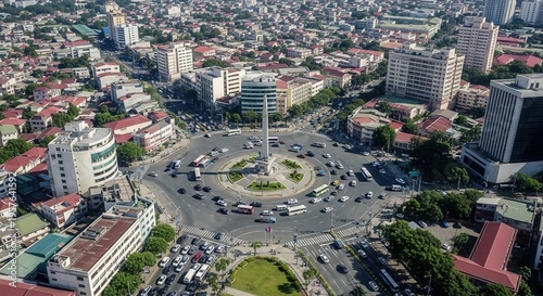 Bustling Cityscape With Monument And Traffic In A Circular Intersection
