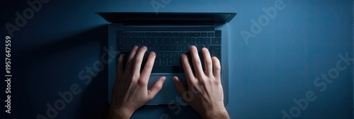 Hands typing on laptop keyboard overhead view blue background communication