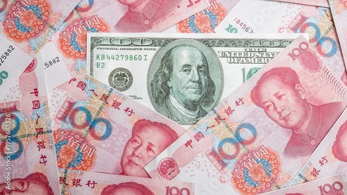 Background of Chinese yuan banknotes with US dollar bill in focus. Concept of economic power, currency exchange, global trade relations, and financial markets, Yuan banknotes surrounding a dollar bank