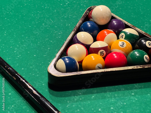 Fotografie Billiard balls sit in a triangle on the green table, ready for players to start the game