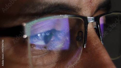 Man's eye reflecting a computer screen at night