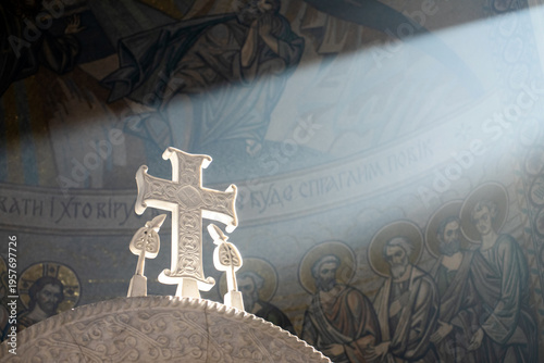 A ray of sunlight falls on a beautiful marble cross inside an Orthodox church
