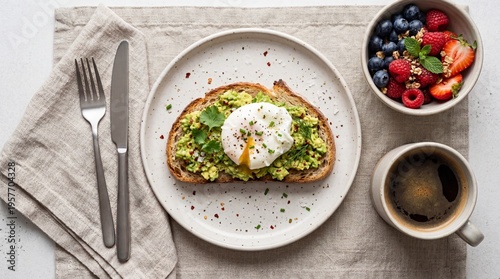 healthy breakfast options, avocado toast with poached egg and herbs sits on a napkin next to berries, granola, and black coffee