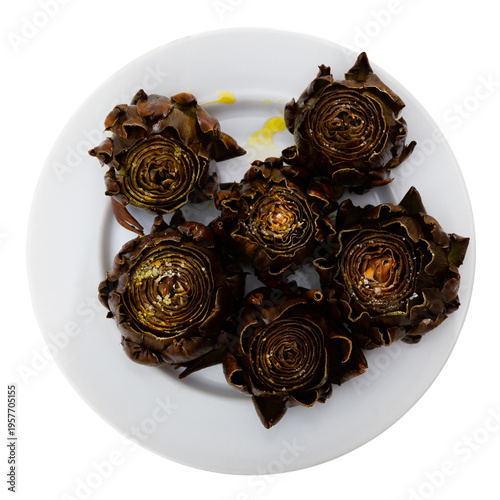 Crispy baked artichoke on a ceramic plate on a table with cutlery. Artichokes with spices for an appetizer. Isolated over white background