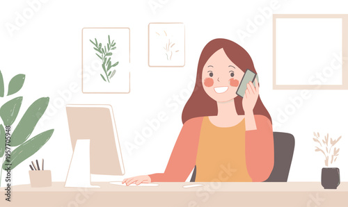 Smiling woman working at a desk on her computer while talking on the phone