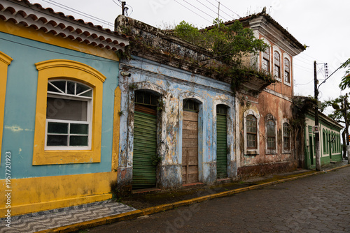 Vibrant, weathered Portuguese colonial buildings line a cobblestone street in Cananeia , Brazil. Soft, diffused light emphasizes the unique architecture.