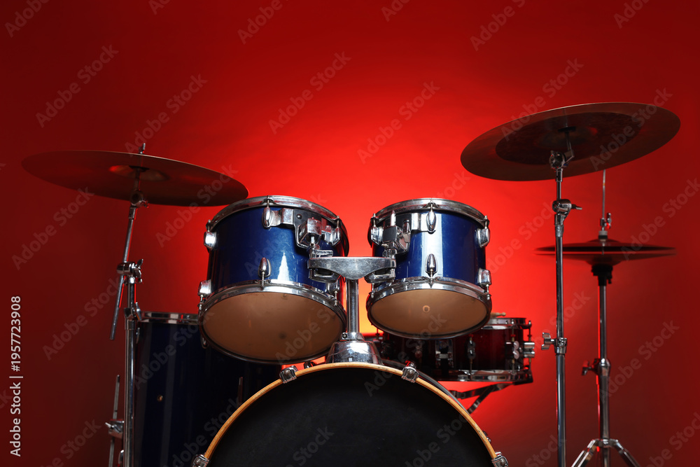 Obraz premium Drum kit on red gradient background, low angle view. Musical instruments