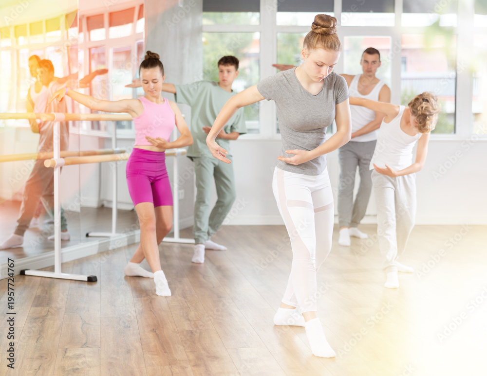 Fototapeta premium Girls and boys are learning various dance and ballet movements in the studio