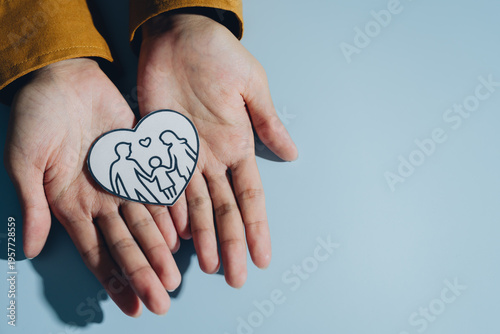 Фотография Hands hold heart shaped drawing depicting family, symbolizing love and togetherness