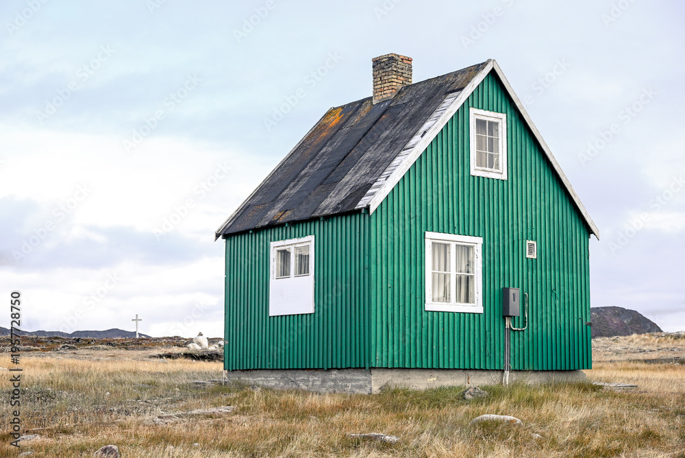 Obraz premium Ilimanaq, Disko Bay, Greenland - Green House in Remote Ilimanaq Greenland with Arctic Tundra and Cross, Minimal Landscape Scene