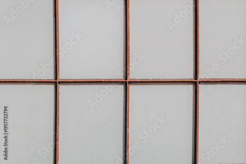 Light gray panel wall with rusted metal grid pattern