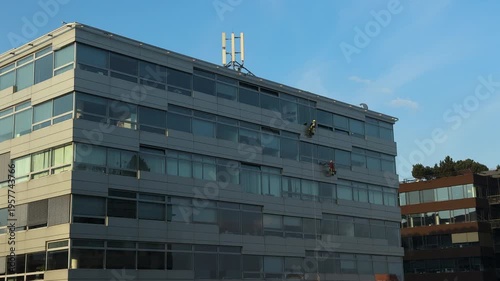 Two Rope Access Technicians Abseiling on Glass Office Building Facade