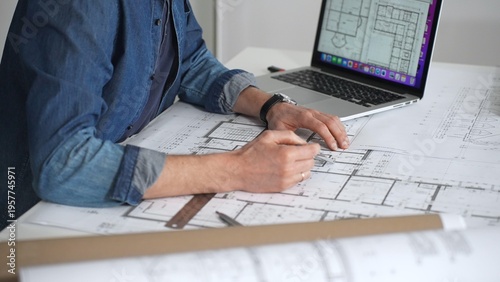 Quadro su tela Architect drawing and measuring blueprints on a desk, creating detailed floor pl