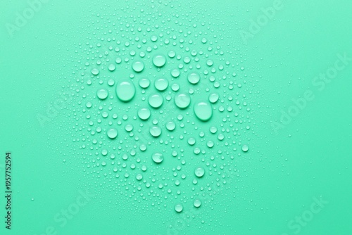 Fotografie Many water drops on green background, top view