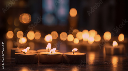 Hands-free prayer candles softly glowing in a dim interior space, warm flickering light creating gentle bokeh, dark blurred background, peaceful reflective religious atmosphere, cinematic wide framing