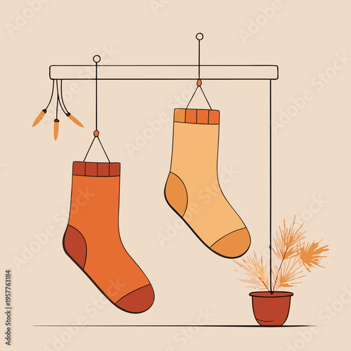 Warm toned socks hanging on a minimalist rack beside a potted plant with dried foliage
