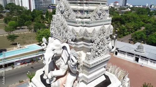 Aerial view of a detailed white temple featuring an elephant deity statue and intricate carvings