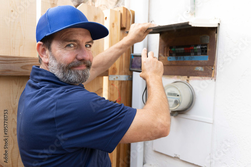 home inspector taking infrared thermography camera pictures of an electrical panel