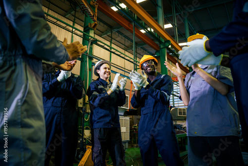 Factory team applauding worker achievement in industrial plant