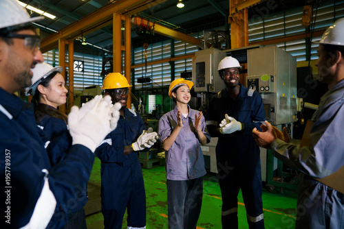 Factory team applauding worker achievement in industrial plant