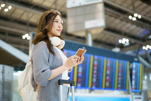 Young woman checking flight schedule for her summer vacation