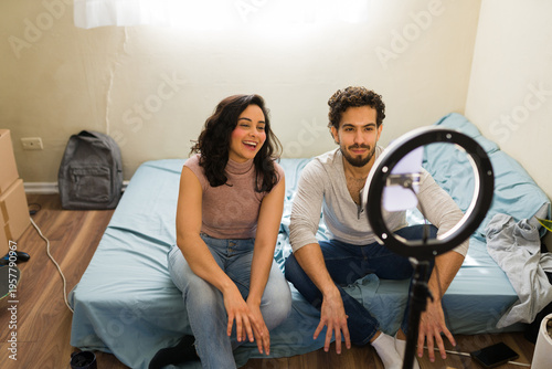 Young couple creating social media content in their first apartment, making ends meet and living on a budget