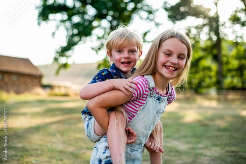 Konstfotografi Joyful siblings playing outdoors.