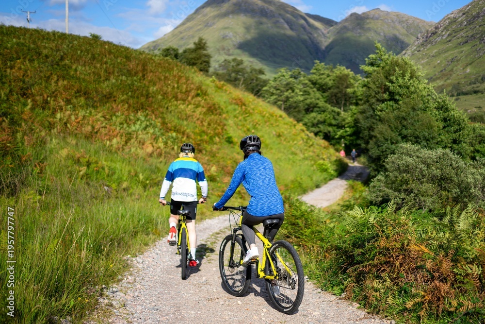 Fototapeta premium Cyclists exploring scenic mountain trails.