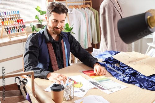 Male tailor drawing at tabl...