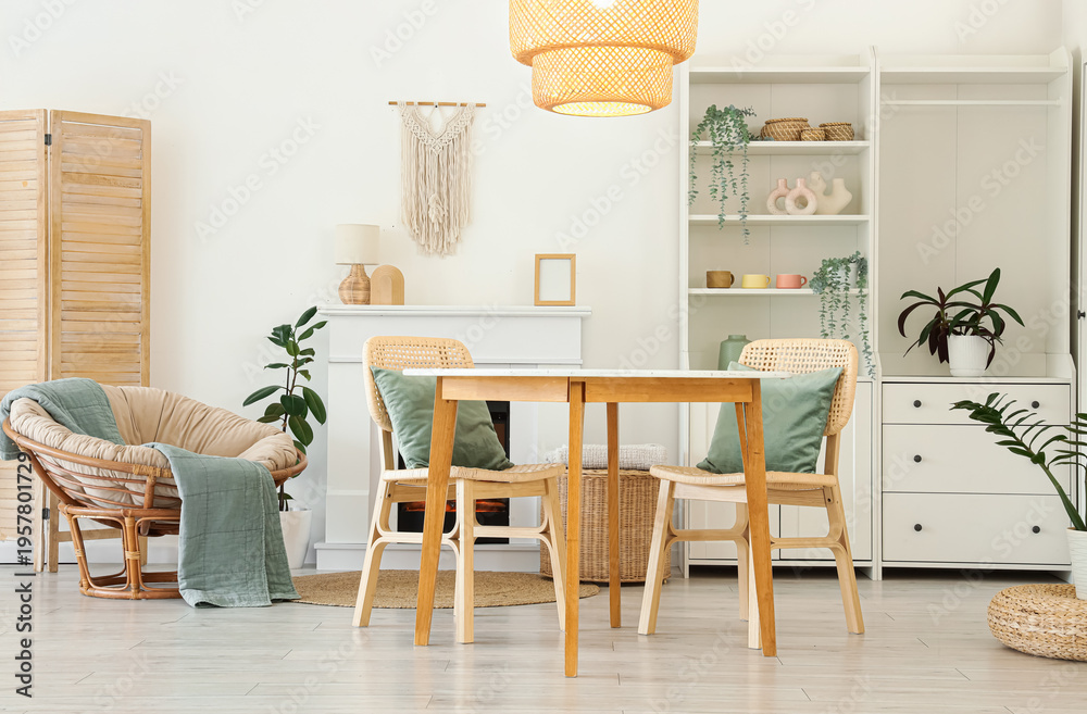 Fototapeta premium Interior of stylish dining room with table, armchair, fireplace and glowing lamp