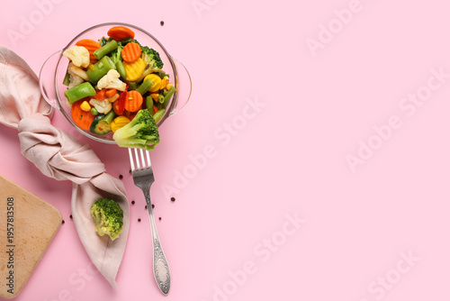Canvas Print Colorful mixed vegetables in glass bowl with fork on pink background, healthy ve