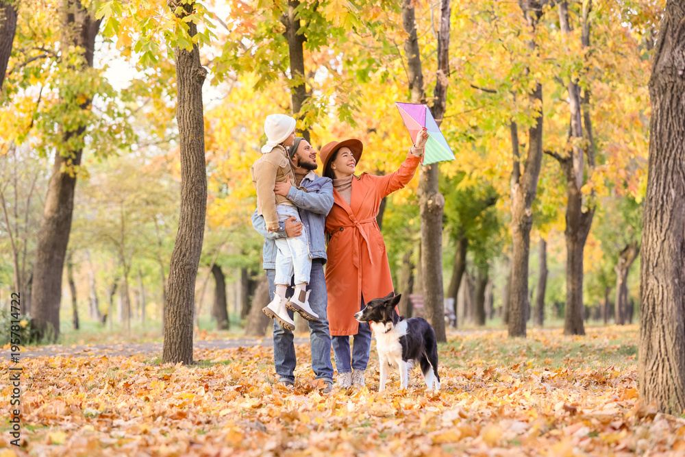 Fototapeta premium Happy family with kite and dog in autumn park