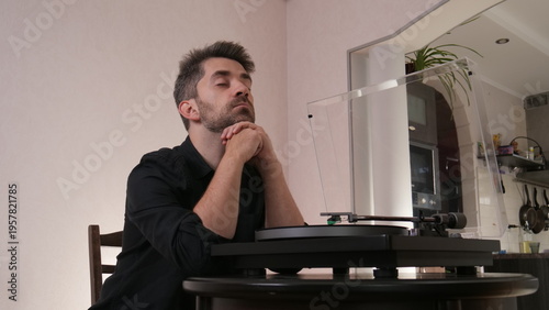 Cuadro en lienzo Bearded man with eyes closed enjoying warm analog vinyl sound from a vintage tur