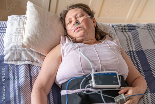 Cuadro en lienzo Woman resting in bed with home medical monitoring device, nasal cannula oxygen,