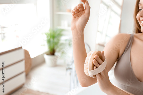 Woman dry brushing arm with...