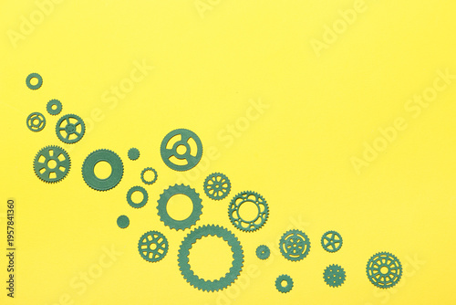 Green paper gears on yellow...