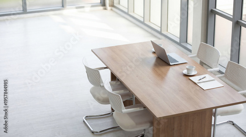 Schilderij op canvas High angle photograph of a minimalist modern office meeting table with a single laptop and coffee for focused work