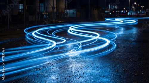 Photos Abstract long exposure photograph of wavy blue light trails on a dark, wet city street