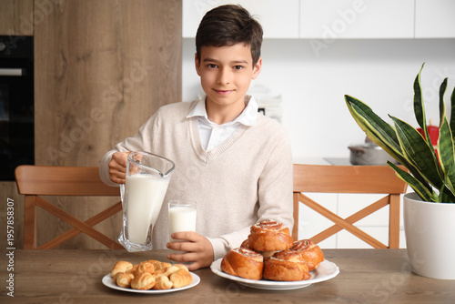 Little boy pouring milk int...