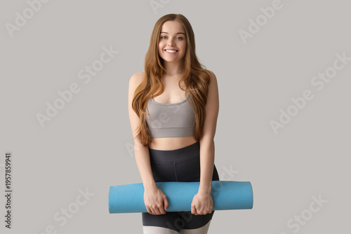 Sporty young woman with yog...